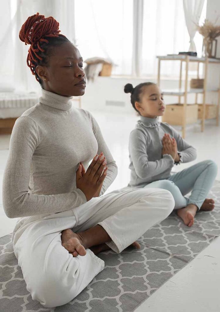 como aprender a meditar: mãe e filha meditando juntas.